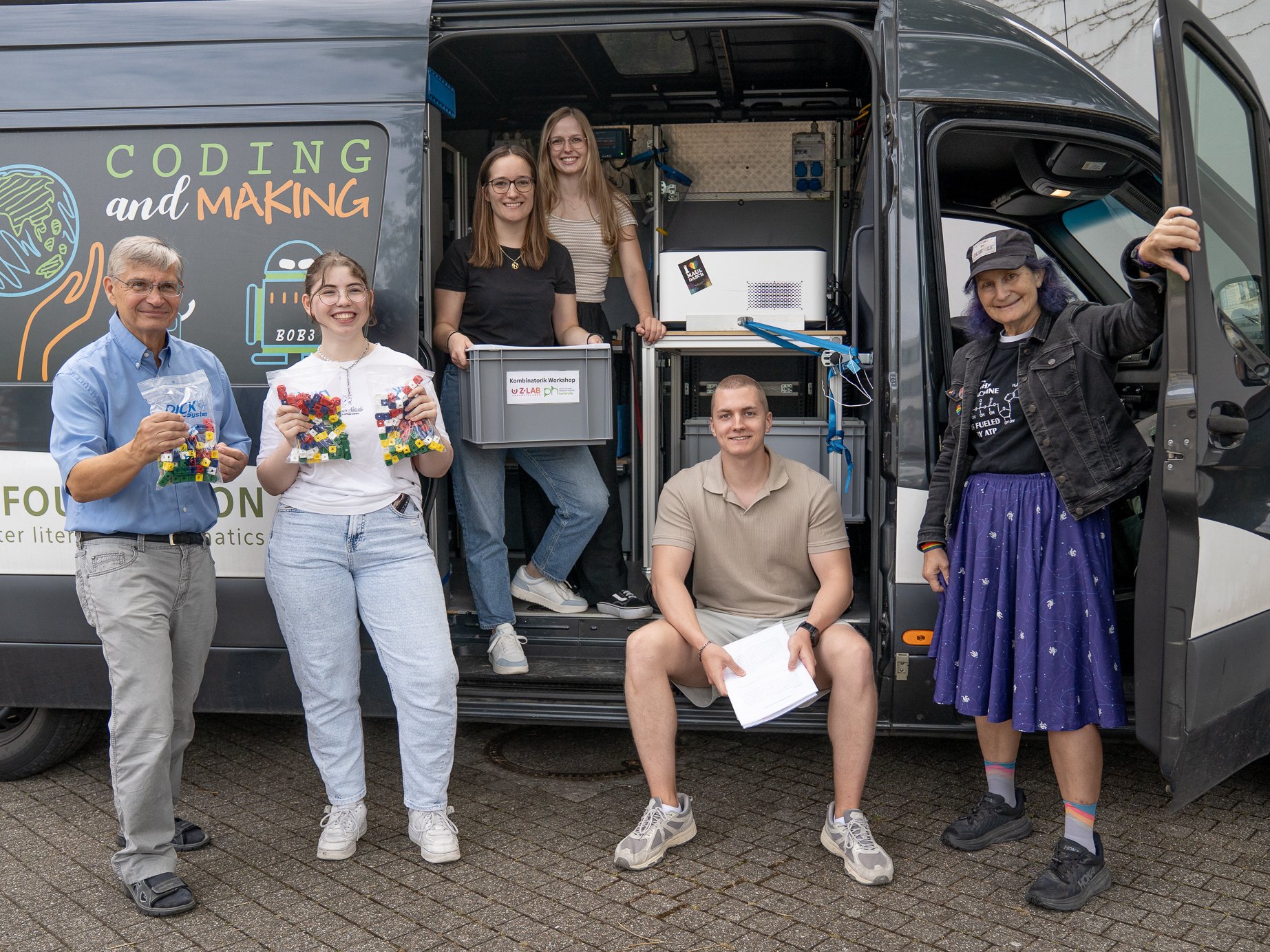 Sommer 2026: Der Begeisterbus mit Dr. Silvia Zinser (r.) macht Station an der PHKA. Dr. Borys (l.) und PHKA-Lehramtsstudierende präsentieren die Workshopmaterialien. Foto: PHKA/Hahl