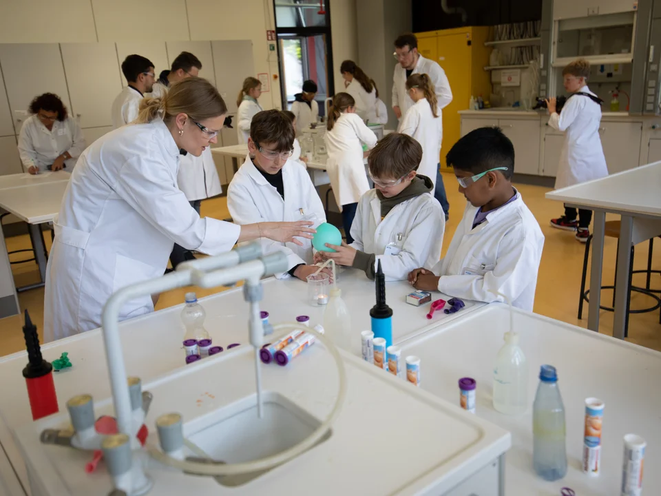 Eine Lehrerin und eine Schulklasse in einem Chemielabor