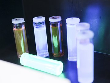 Mehrere schmale Gläser mit Deckel, die verschiedenfarbige chemische Lösungen enthalten.