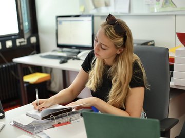 Eine junge Frau bearbeitet den Inhalt eines Ordners
