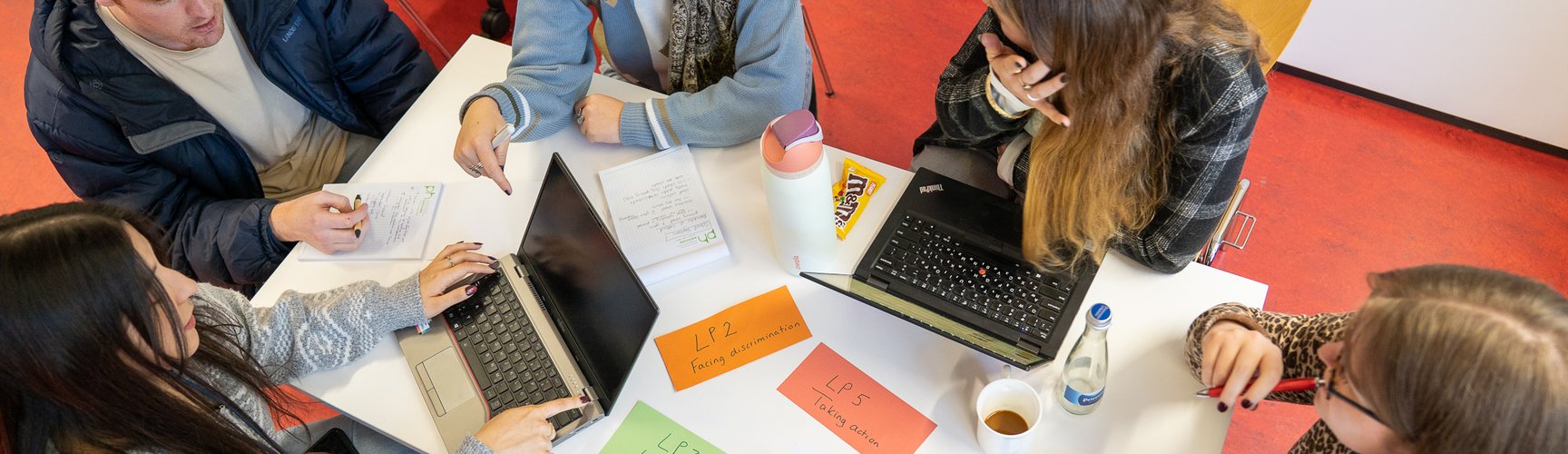 Eine Gruppe von Studierenden arbeitet gemeinsam an einem Tisch.