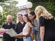Eine Gruppe Studierender schaut gemeinsam in einen Laptop