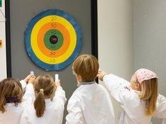 Kinder zielen auf eine Zielscheibe
