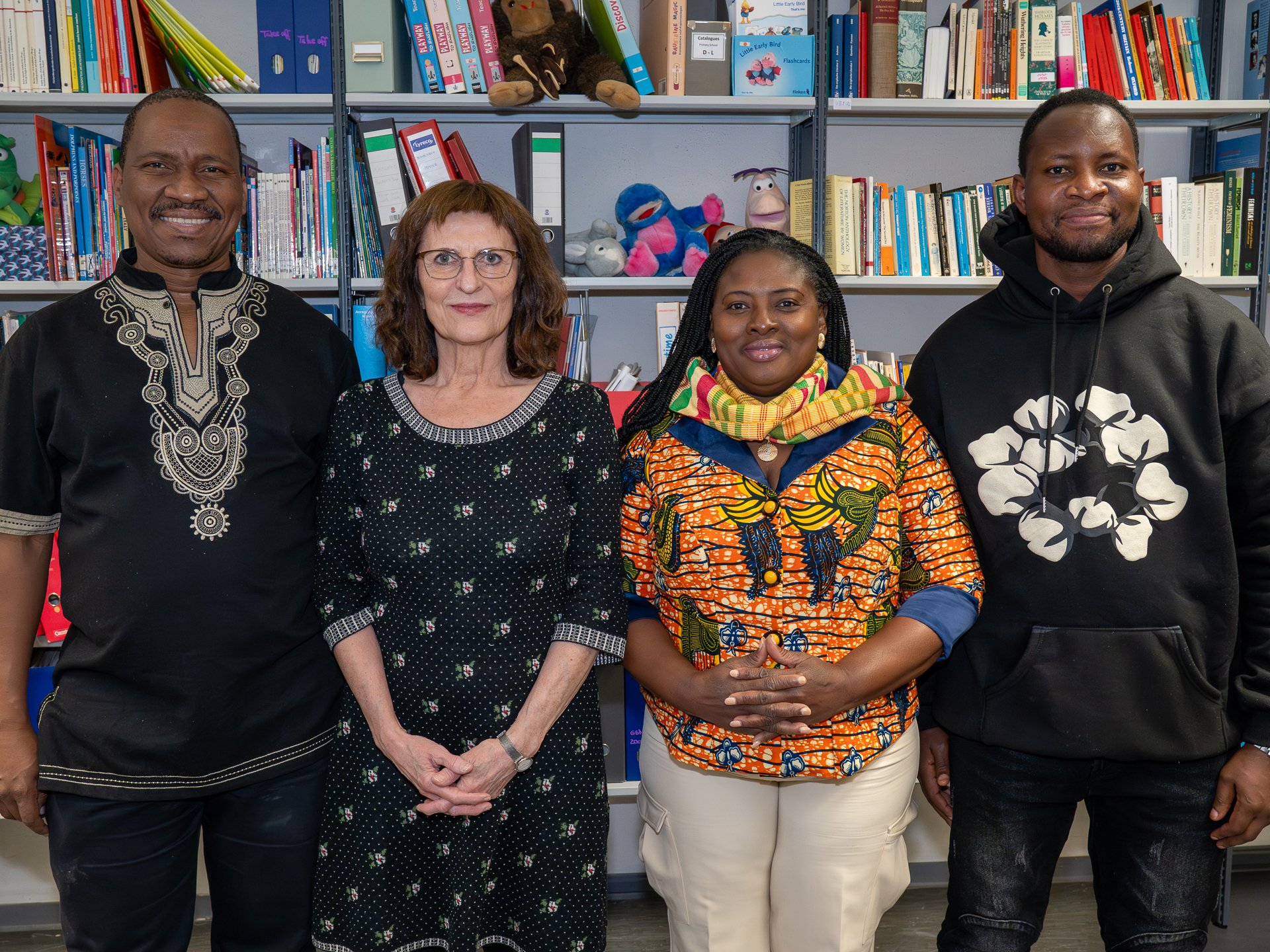 Vier Personen, die lächelnd in die Kamera schauen 