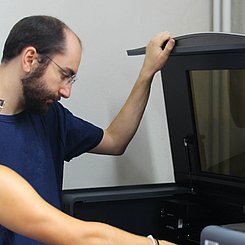 Zwei Personen bedienen einen Lasercutter