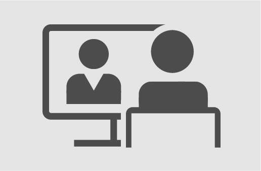 Druck Eine Person sitzt an ihrem Schreibtisch und hört einer Person, die auf dem Bildschirm abgebildet ist zu